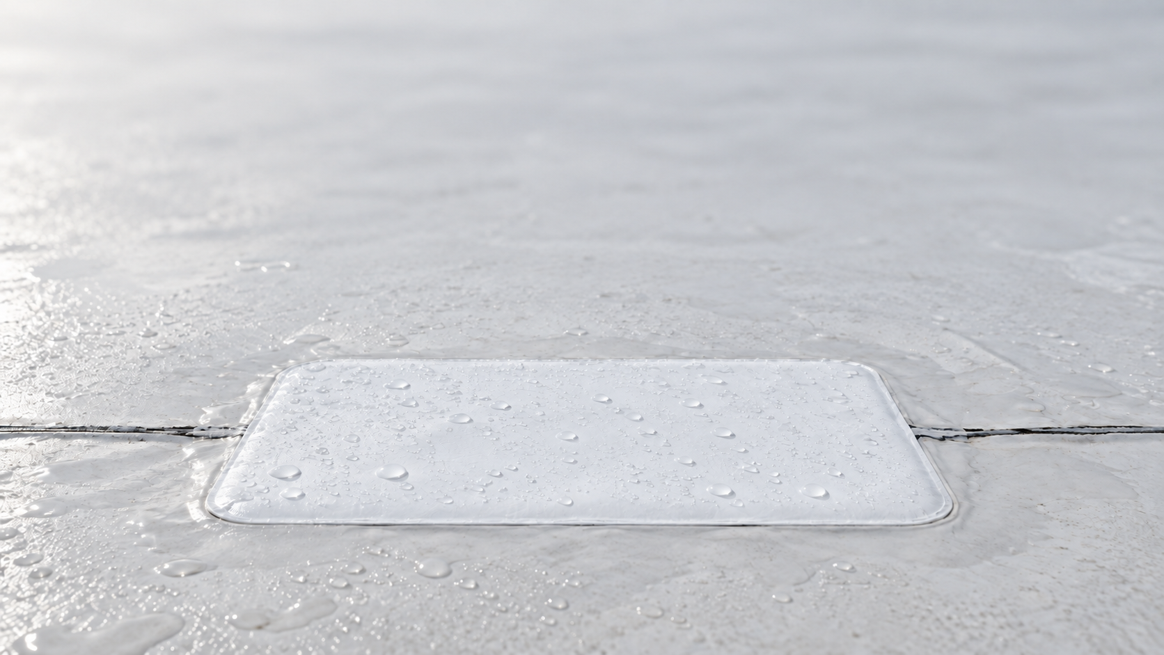 A white waterproof repair patch sealing a seam on a wet white roof