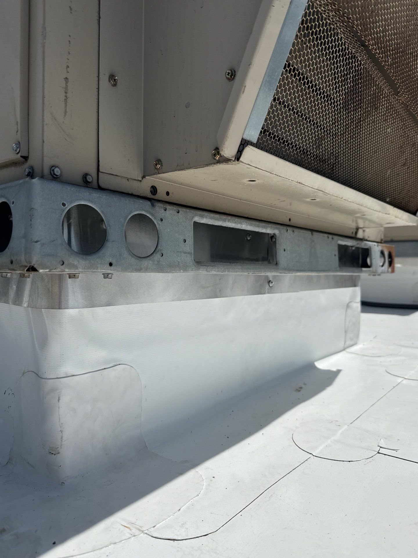 New membrane heat-welded up the curb of a rooftop HVAC unit