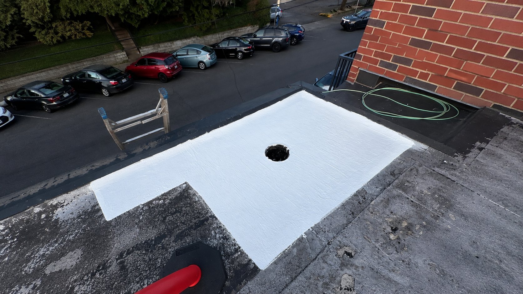 A newly coated repair around a commercial roof drain