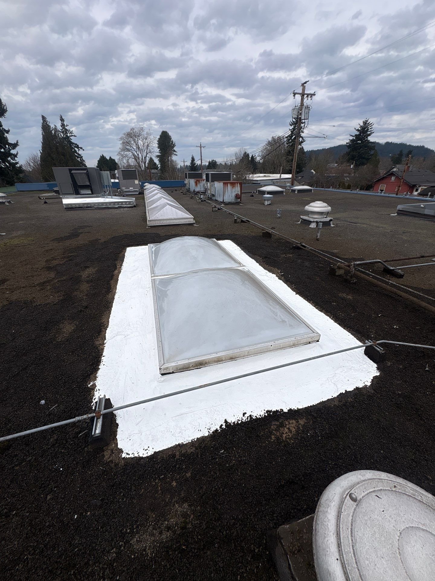 A newly coated repair around a commercial roof skylight