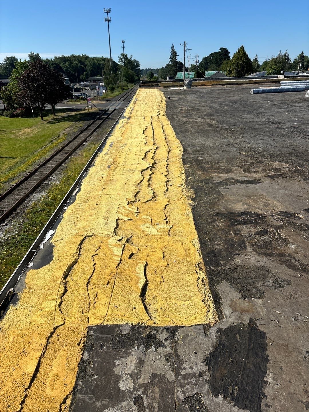 A split foam repair strip along the edge of a weathered commercial roof
