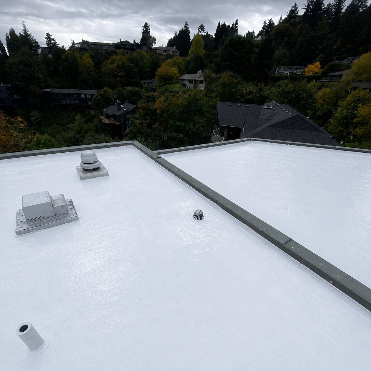A coated roof drain in a low area of a white silicone roof that used to hold water
